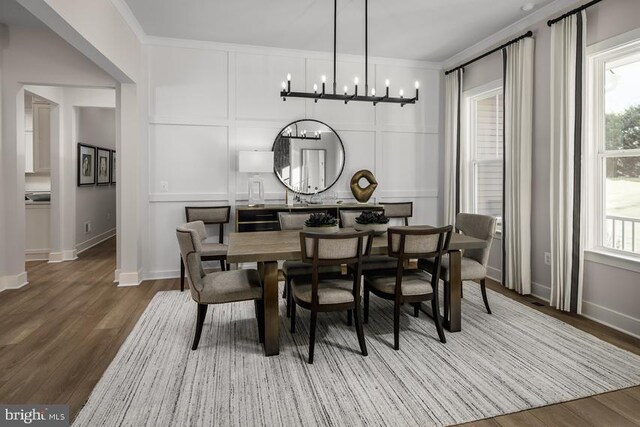 dining area with plenty of natural light, crown molding, wood finished floors, and an inviting chandelier