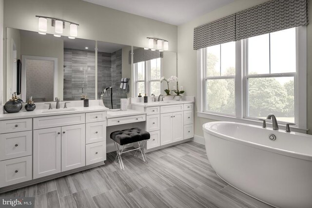 full bath featuring a sink, a stall shower, two vanities, and plenty of natural light