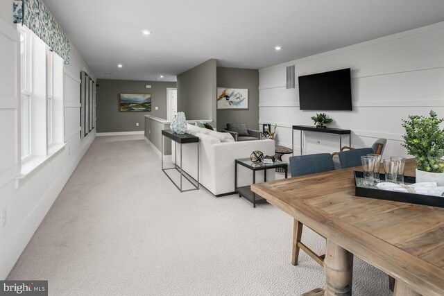 living area featuring a wealth of natural light, light colored carpet, and recessed lighting