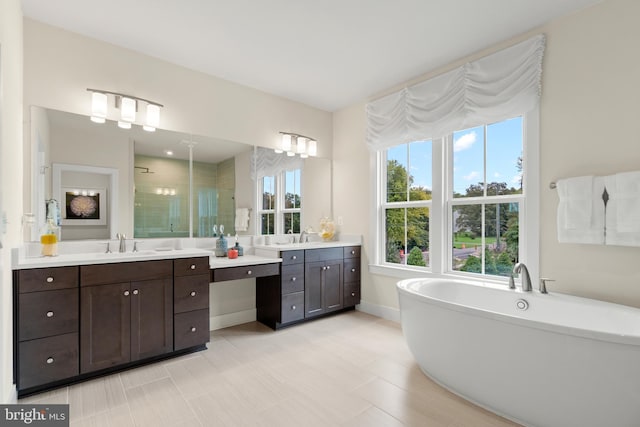 bathroom featuring baseboards, a soaking tub, a sink, a stall shower, and two vanities