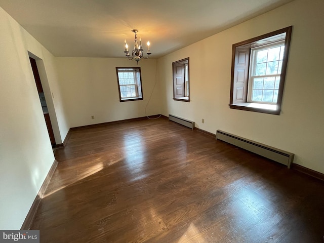 unfurnished room featuring an inviting chandelier, dark wood finished floors, baseboards, and baseboard heating