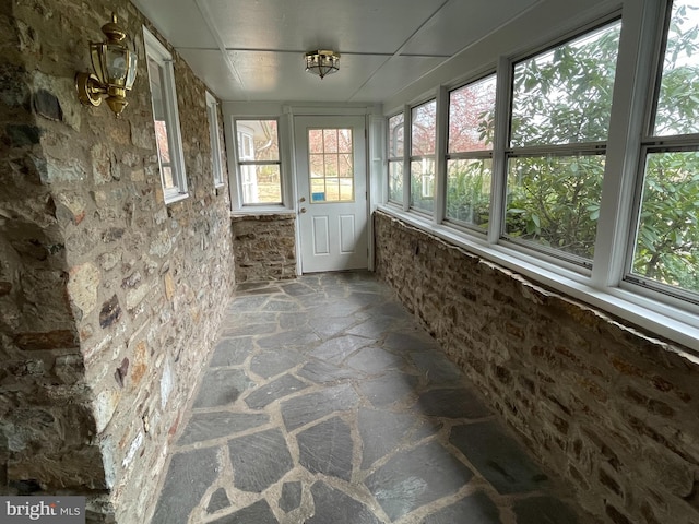 unfurnished sunroom with stone floors