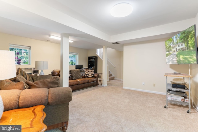 carpeted living room featuring healthy amount of natural light, stairway, and baseboards