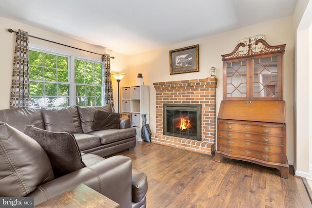 living room with dark wood-style floors and a brick fireplace