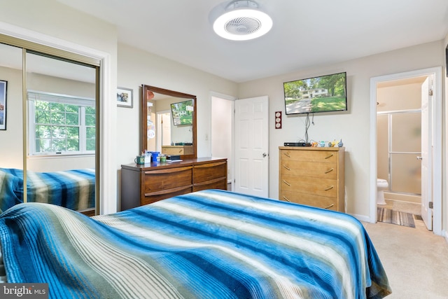 carpeted bedroom with ensuite bath and a closet