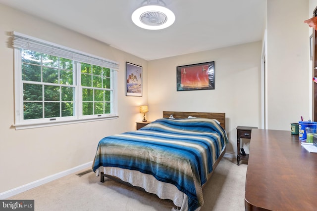 carpeted bedroom featuring multiple windows and baseboards