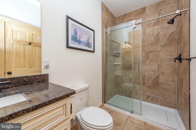 full bathroom featuring a shower stall, toilet, and vanity