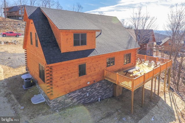 back of house featuring log siding, a deck, central AC, and roof with shingles