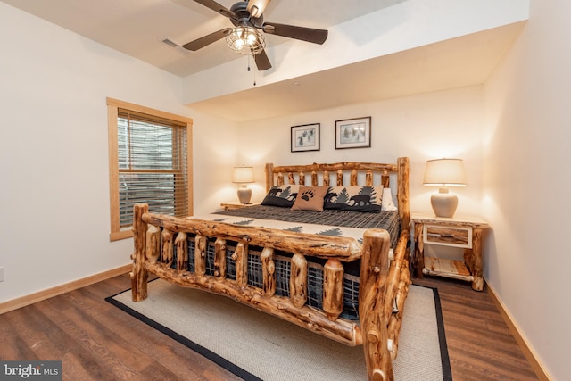 bedroom featuring baseboards, visible vents, and wood finished floors