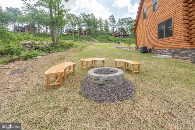 view of yard featuring central air condition unit and a fire pit