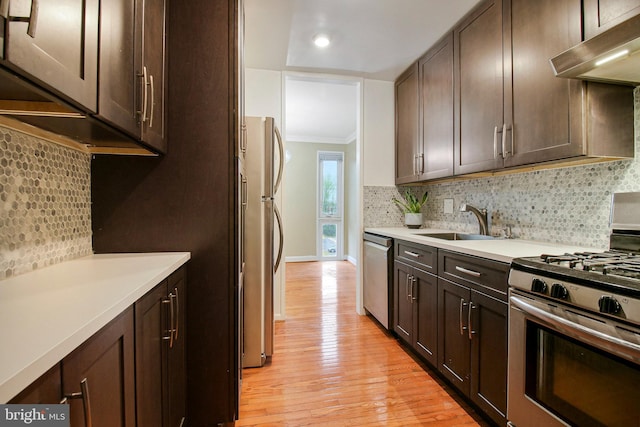 7212 Donnell Pl Unit D5, District Heights, MD 20747 - kitchen featuring a sink, ornamental molding, dark brown cabinetry, under cabinet range hood, and stainless steel appliances