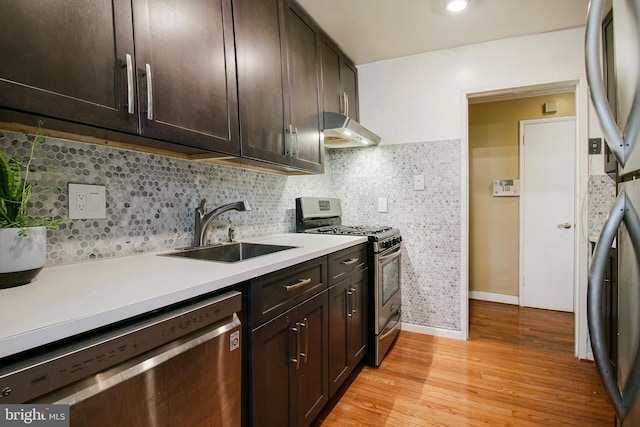 7212 Donnell Pl Unit D5, District Heights, MD 20747 - kitchen featuring light wood-style flooring, under cabinet range hood, a sink, light countertops, and stainless steel appliances