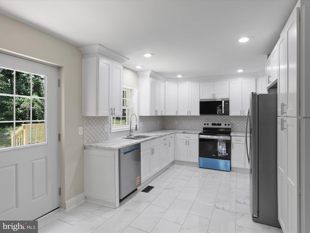 18820 Kerill Rd, Triangle, VA 22172 - kitchen with stainless steel appliances, light marble finish floors, white cabinets, plenty of natural light, and recessed lighting