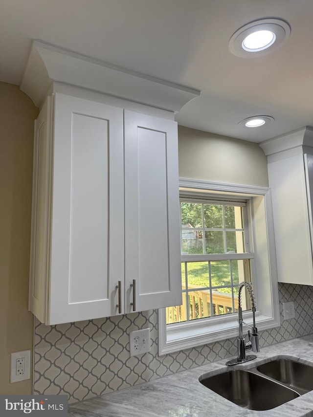 18820 Kerill Rd, Triangle, VA 22172 - kitchen with white cabinets, decorative backsplash, and light stone countertops