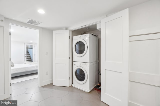 1526 Swann St NW, Washington, DC 20009 - laundry room with stacked washer and clothes dryer, light tile patterned floors, and recessed lighting