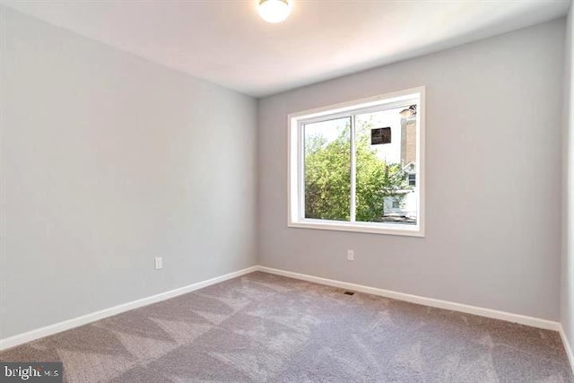 carpeted empty room with baseboards