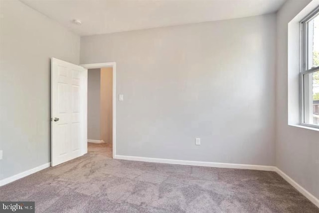 carpeted empty room with healthy amount of natural light and baseboards