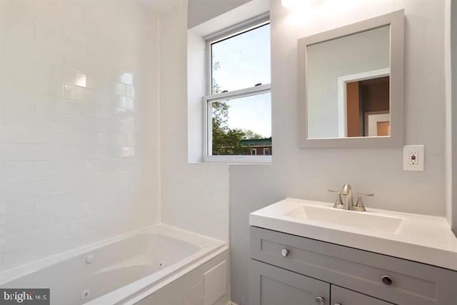 bathroom featuring healthy amount of natural light, vanity, and a combined bath / shower with jetted tub