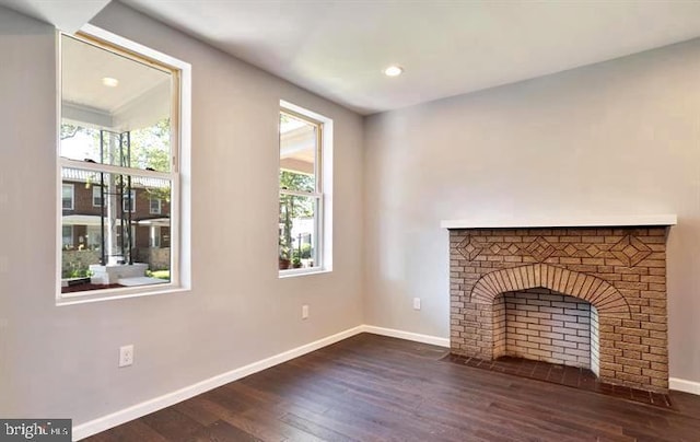 unfurnished living room featuring baseboards, dark wood-type flooring, recessed lighting, and a fireplace