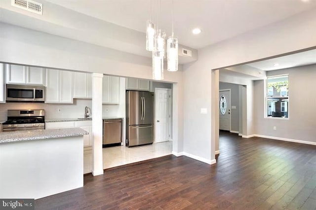 kitchen with stainless steel appliances, dark wood-style floors, light stone countertops, a sink, and recessed lighting