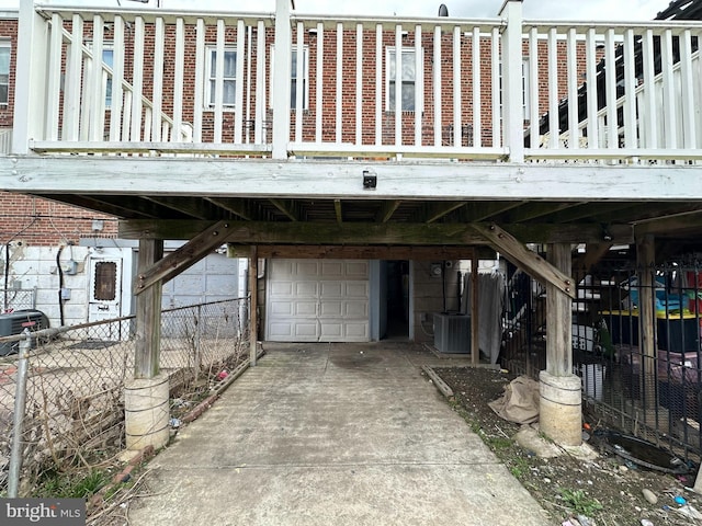 garage with central air condition unit, driveway, a carport, and fence