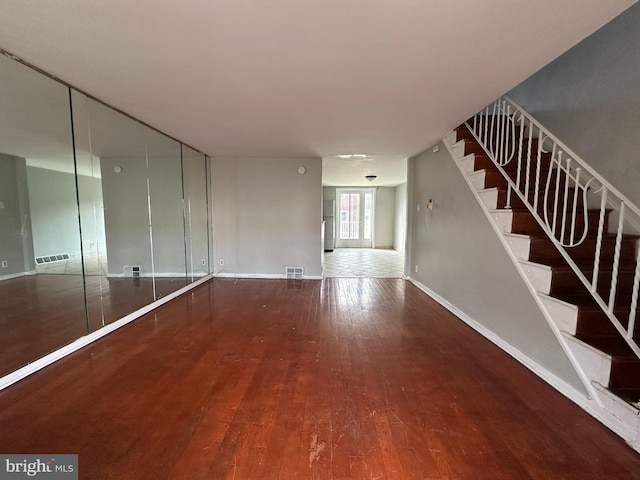 interior space with visible vents, baseboards, stairs, and wood finished floors