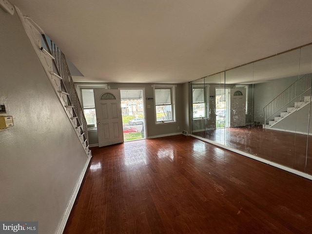 foyer entrance featuring stairs, baseboards, and wood-type flooring