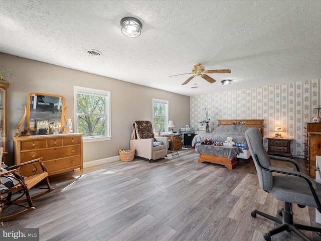 2796 Green Spring Rd, Winchester, VA 22603 - bedroom featuring a textured ceiling, wood finished floors, an accent wall, and wallpapered walls