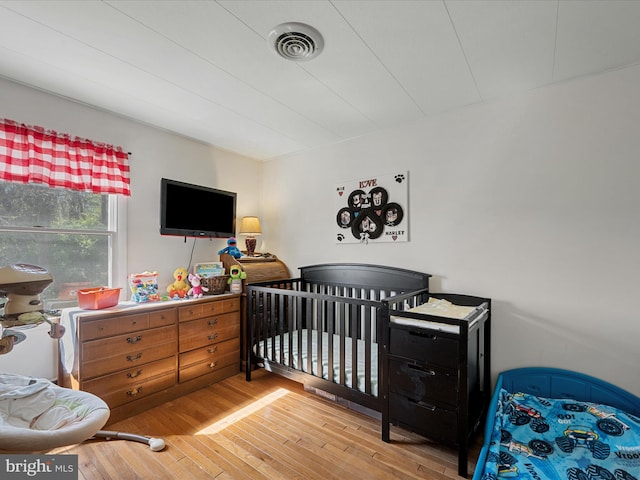 2796 Green Spring Rd, Winchester, VA 22603 - bedroom with wood finished floors, visible vents, and a nursery area