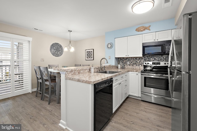 12301 Jamaica Ave Unit E21605, Ocean City, MD 21842 - kitchen featuring visible vents, black appliances, a sink, and a peninsula