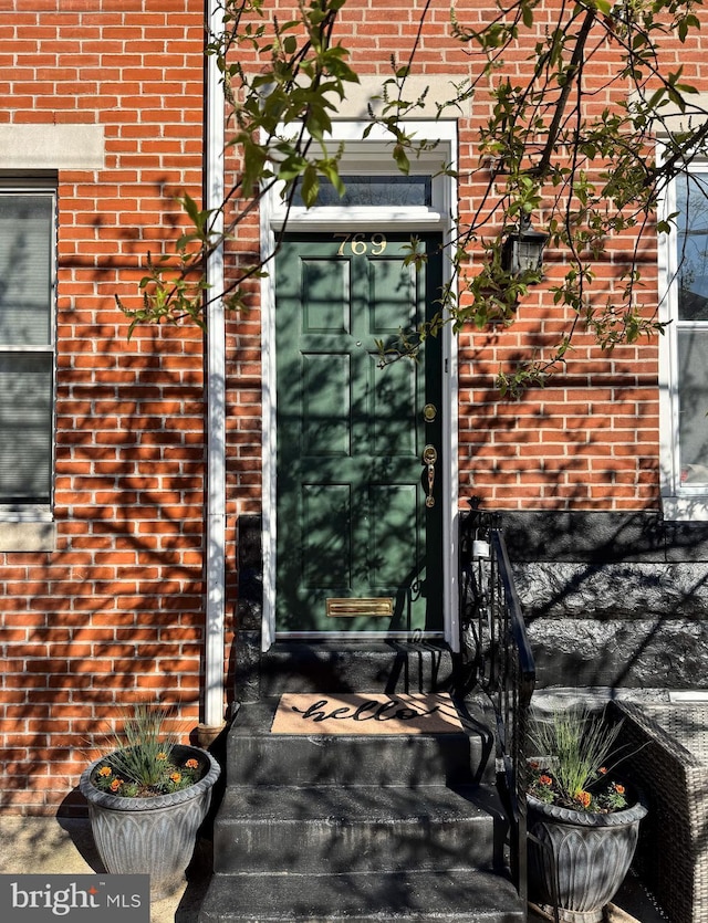 entrance to property featuring brick siding