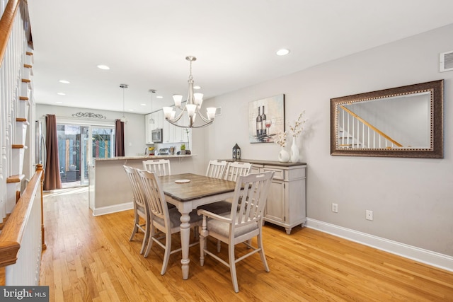 dining area with light wood-type flooring, baseboards, visible vents, recessed lighting, and an inviting chandelier
