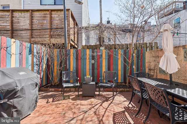 view of patio featuring a grill, outdoor dining area, and a fenced backyard