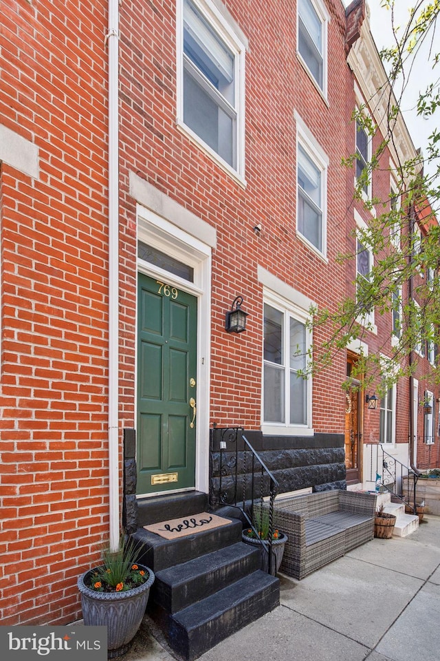 entrance to property featuring brick siding