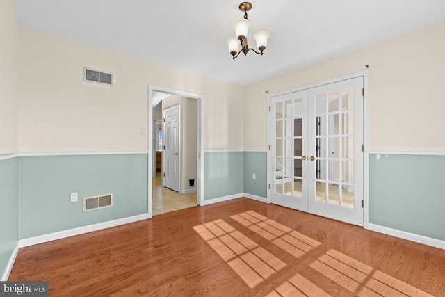 878 Buttermilk Ct, Harrisburg, PA 17111 - empty room with french doors, visible vents, a chandelier, and wood finished floors