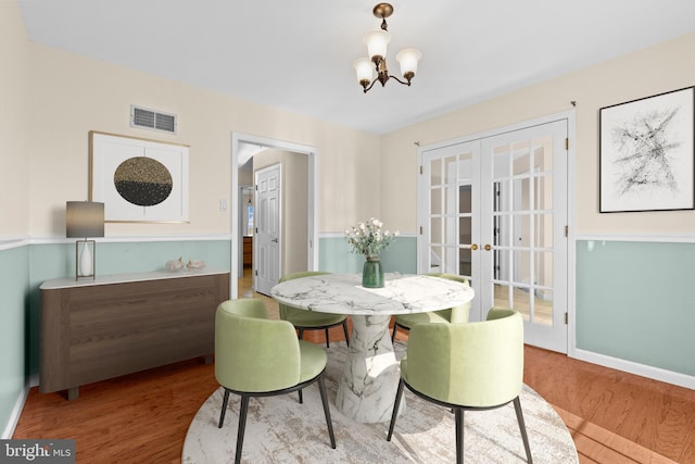 878 Buttermilk Ct, Harrisburg, PA 17111 - dining space featuring visible vents, wood finished floors, french doors, baseboards, and a notable chandelier
