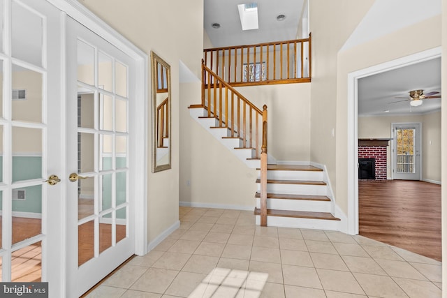 878 Buttermilk Ct, Harrisburg, PA 17111 - entrance foyer with a fireplace, a ceiling fan, a skylight, stairs, and tile patterned floors