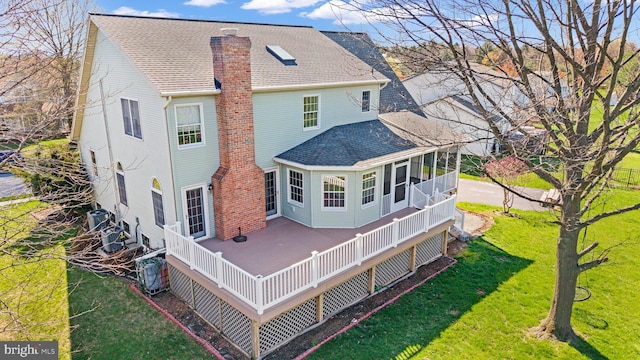 878 Buttermilk Ct, Harrisburg, PA 17111 - back of house featuring a sunroom, a yard, a chimney, a shingled roof, and a deck