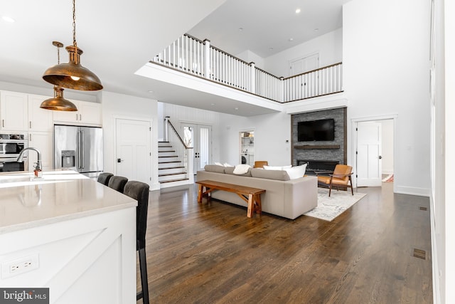 330 Trout Rd, State College, PA 16801 - living area with dark wood-style flooring, a large fireplace, stairs, and a towering ceiling