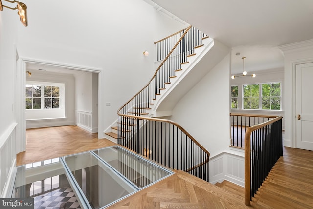 827 Turkey Run Rd, Mclean, VA 22101 - stairway featuring plenty of natural light, a decorative wall, a wainscoted wall, a chandelier, and ornamental molding