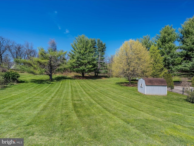 view of yard featuring an outbuilding, a shed, and fence
