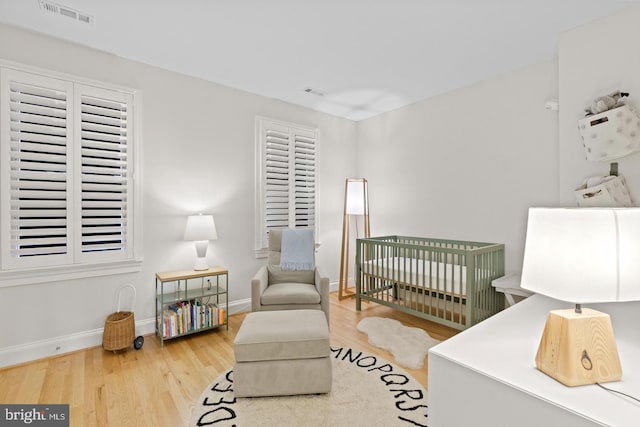 808 Cameron St, Alexandria, VA 22314 - bedroom with a crib, wood finished floors, and baseboards