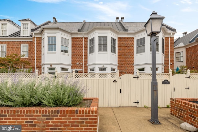 808 Cameron St, Alexandria, VA 22314 - view of side of home featuring a gate, brick siding, and a standing seam roof