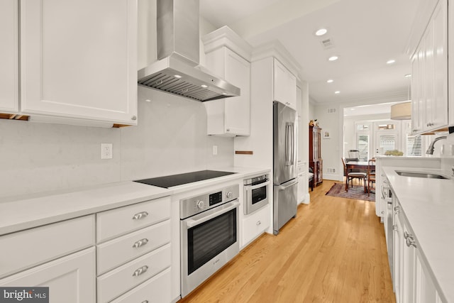 808 Cameron St, Alexandria, VA 22314 - kitchen featuring wall chimney exhaust hood, stainless steel appliances, a sink, white cabinets, and light countertops