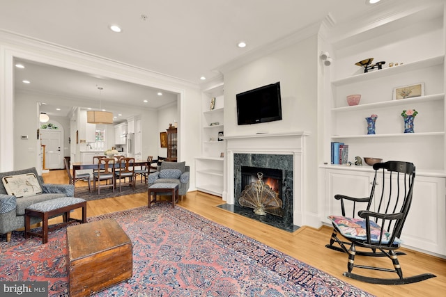 808 Cameron St, Alexandria, VA 22314 - living room with built in features, light wood-style floors, ornamental molding, a fireplace, and recessed lighting