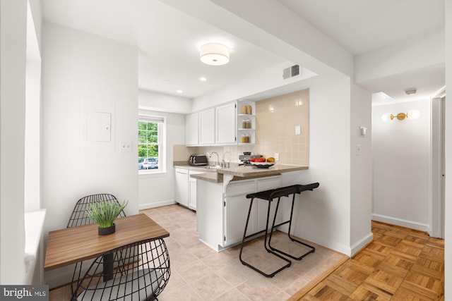 2107 N Taft St Unit 11, Arlington, VA 22201 - kitchen featuring open shelves, white cabinetry, a kitchen bar, dishwasher, and decorative backsplash