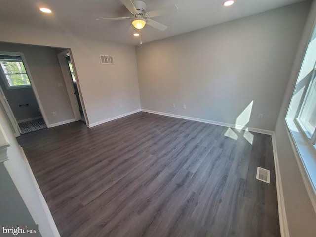 empty room featuring baseboards, dark wood-type flooring, recessed lighting, and visible vents