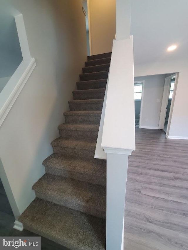 staircase featuring recessed lighting, baseboards, and wood finished floors