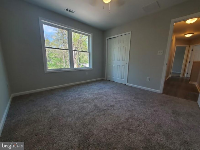 unfurnished bedroom featuring visible vents, carpet, baseboards, and a closet
