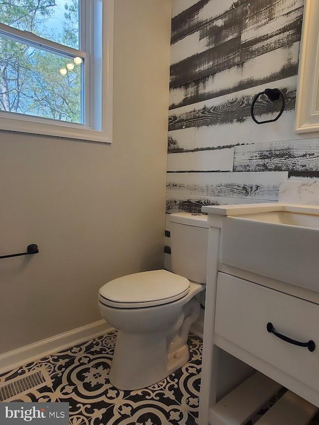 bathroom featuring vanity, baseboards, tile patterned floors, and toilet